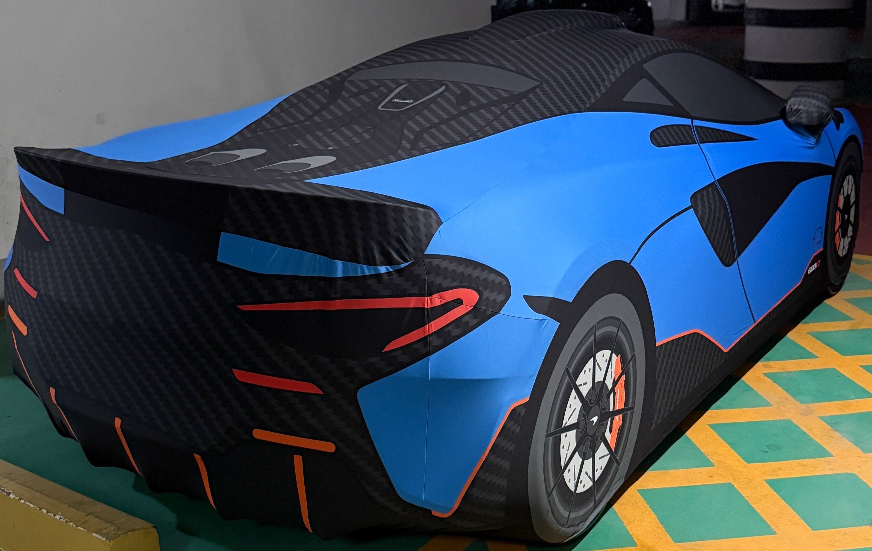 Custom TyreDox bespoke indoor car cover fitted to a blue McLaren 600LT, showcasing premium tailored protection with carbon-effect detailing and precision fitment.